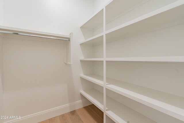 spacious closet with hardwood / wood-style floors