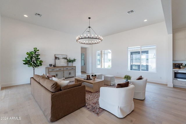 living room featuring a chandelier and light hardwood / wood-style flooring