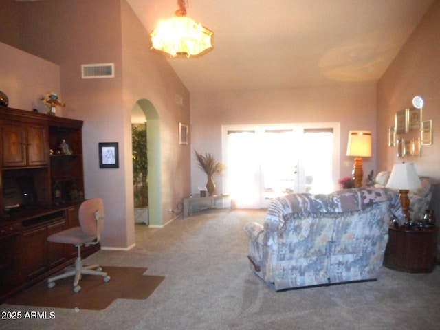 9203 W Behrend Dr, Peoria, AZ 85382 - carpeted living area featuring arched walkways, a chandelier, and high vaulted ceiling