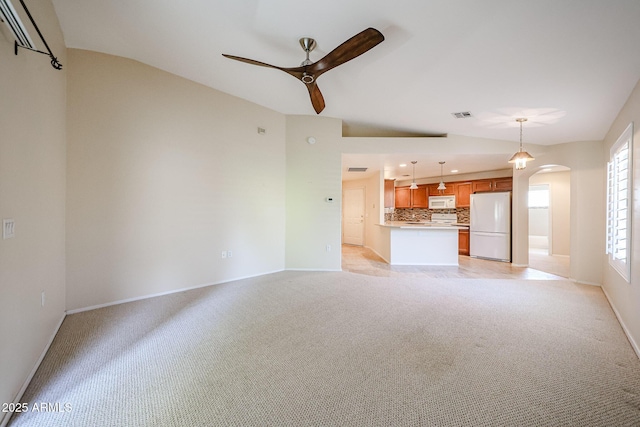 5249 E Shea Blvd Unit 215, Scottsdale, AZ 85254 - unfurnished living room featuring a ceiling fan, light carpet, arched walkways, and lofted ceiling