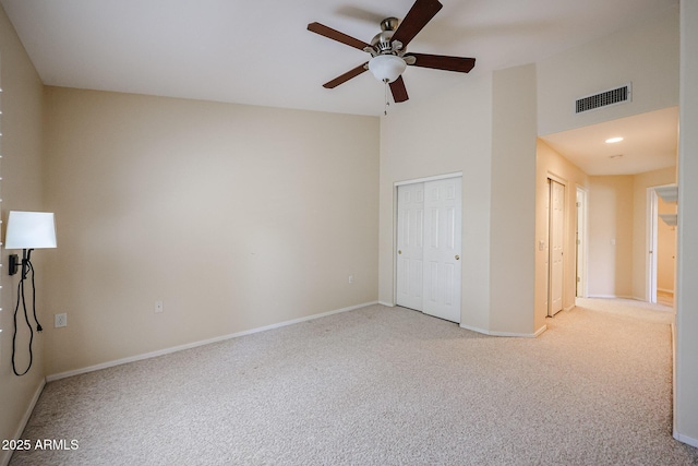 5249 E Shea Blvd Unit 215, Scottsdale, AZ 85254 - unfurnished bedroom featuring carpet floors, a towering ceiling, multiple closets, and a ceiling fan