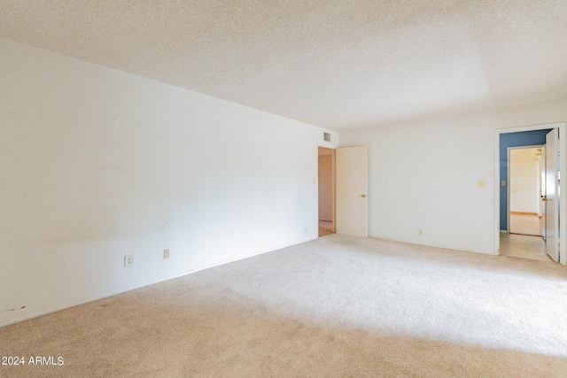 carpeted empty room with a textured ceiling