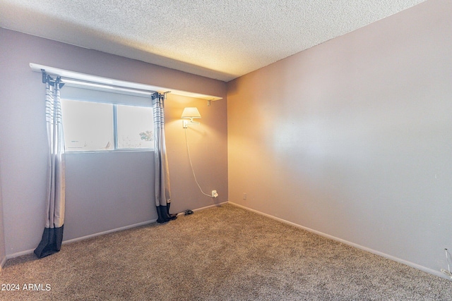 carpeted spare room with a textured ceiling