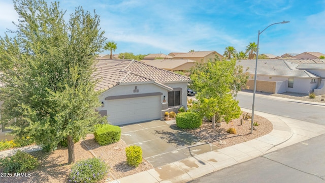 46068 W Guilder Ave, Maricopa, AZ 85139 - view of front of home with driveway, a tile roof, an attached garage, stucco siding, and a residential view