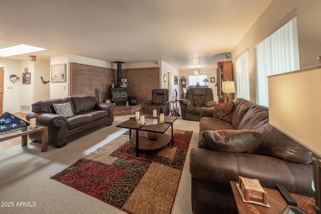 1147 Pedro Ct, Rio Rico, AZ 85648 - carpeted living room featuring a wood stove, a skylight, and a textured ceiling