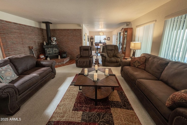 1147 Pedro Ct, Rio Rico, AZ 85648 - living area featuring plenty of natural light, a wood stove, brick wall, and carpet