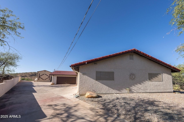 1147 Pedro Ct, Rio Rico, AZ 85648 - view of home's exterior featuring a garage, a tiled roof, stucco siding, and concrete driveway