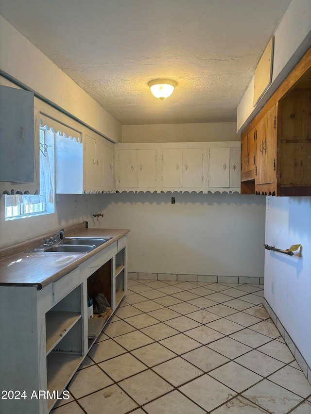 kitchen featuring white cabinets, a textured ceiling, and sink