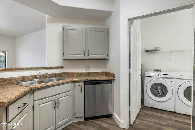 clothes washing area with dark hardwood / wood-style flooring, sink, and washing machine and clothes dryer