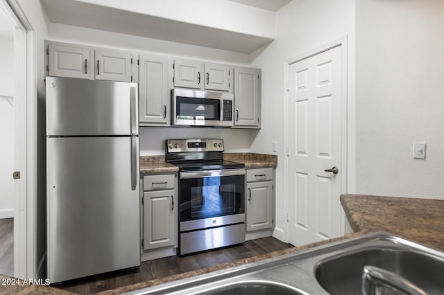 kitchen featuring appliances with stainless steel finishes, dark hardwood / wood-style floors, and gray cabinets