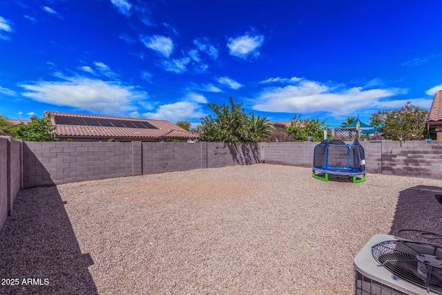 36480 W El Greco St, Maricopa, AZ 85138 - view of yard with a trampoline, a fenced backyard, and central AC unit