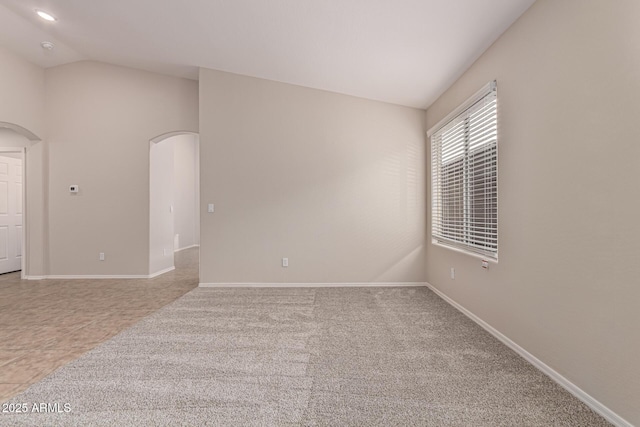 spare room featuring tile patterned floors and lofted ceiling