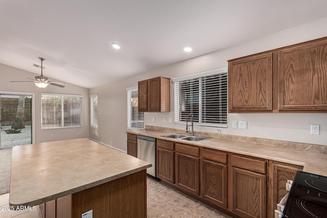 kitchen with sink, vaulted ceiling, ceiling fan, appliances with stainless steel finishes, and a kitchen island