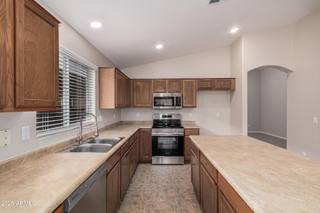 kitchen with stainless steel appliances, lofted ceiling, and sink