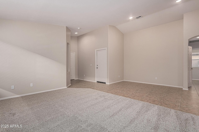 empty room featuring light tile patterned floors and lofted ceiling