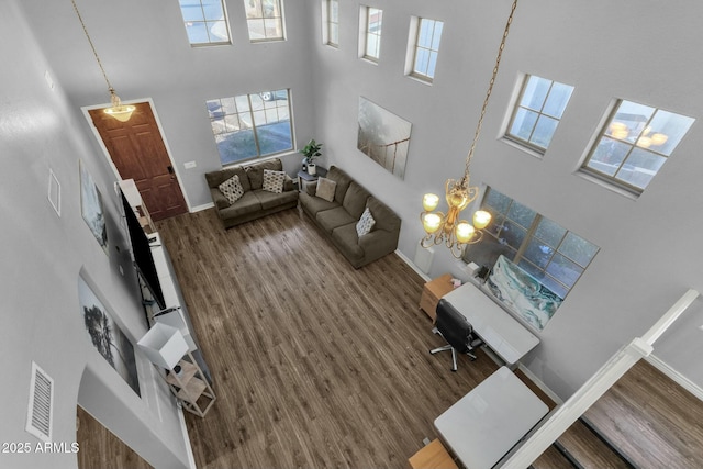 living room with wood-type flooring and a towering ceiling