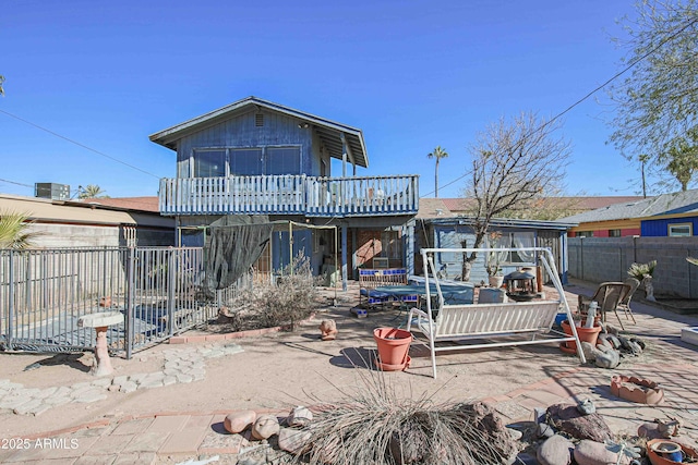 rear view of property featuring a patio area and a trampoline