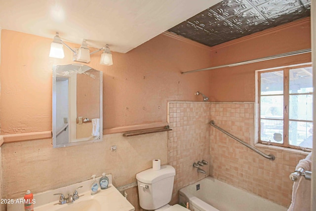 full bathroom featuring sink, tiled shower / bath, crown molding, and toilet