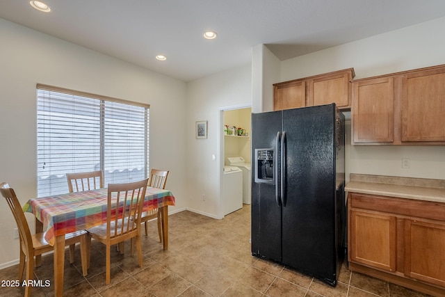 kitchen with black fridge with ice dispenser and washing machine and dryer