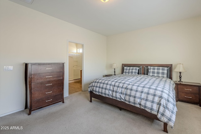 bedroom featuring light colored carpet and ensuite bathroom