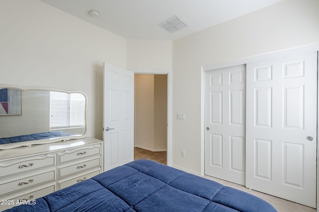 bedroom with a closet and light carpet