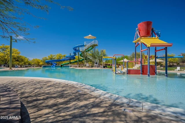 view of pool with a playground and a water slide