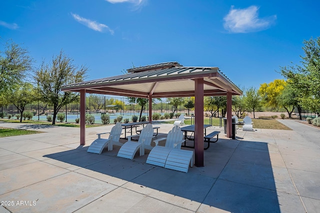 surrounding community featuring a gazebo, a water view, and a patio area