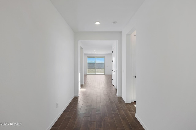 hallway with baseboards and dark wood-style floors