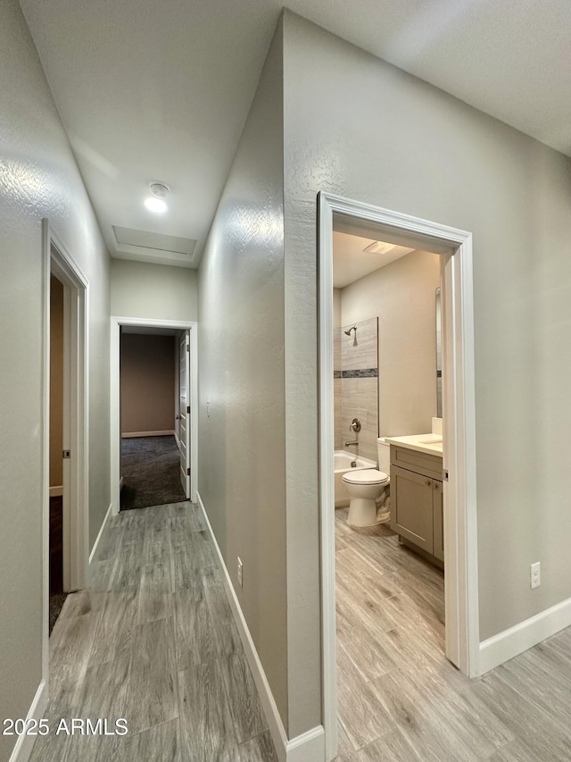 hall with baseboards and light wood-style flooring