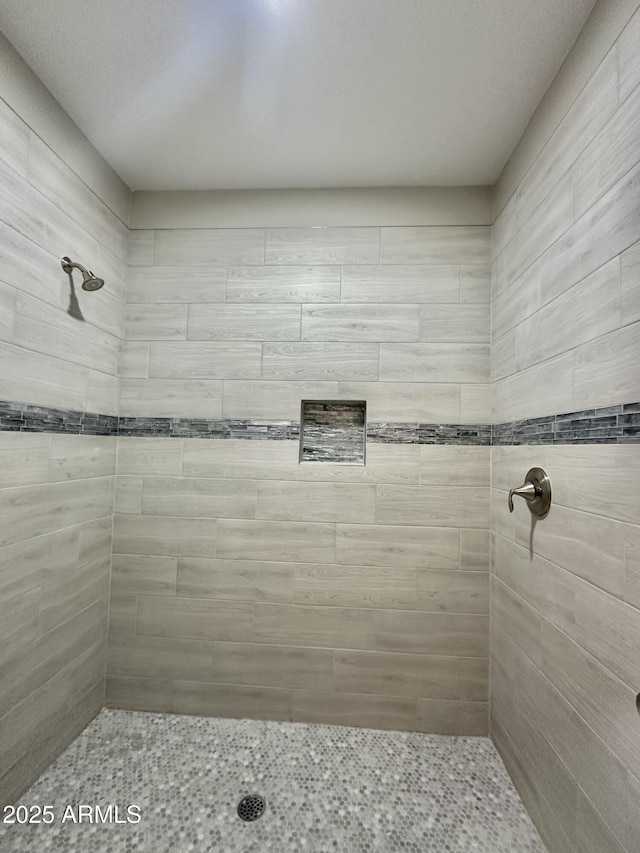 full bath featuring tiled shower