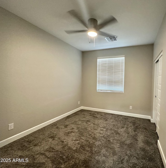 unfurnished bedroom with visible vents, baseboards, a closet, and dark colored carpet
