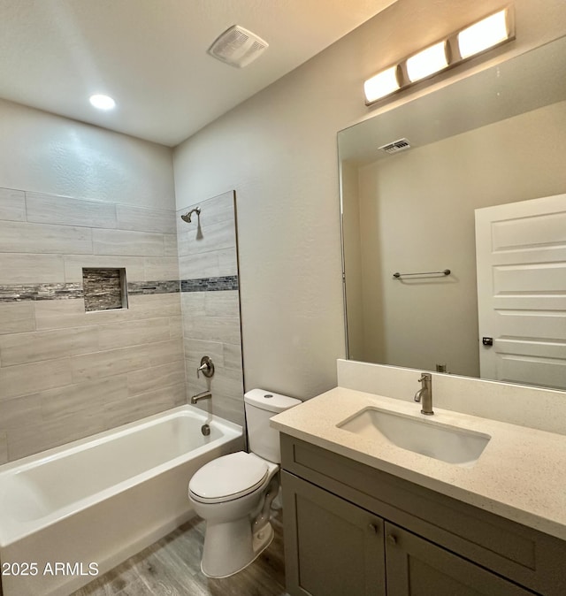 full bath featuring shower / bathtub combination, toilet, visible vents, and wood finished floors