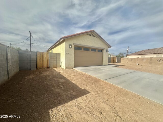 11216 W Apache St, Avondale, AZ 85323 - view of property exterior with stucco siding, fence, and a gate