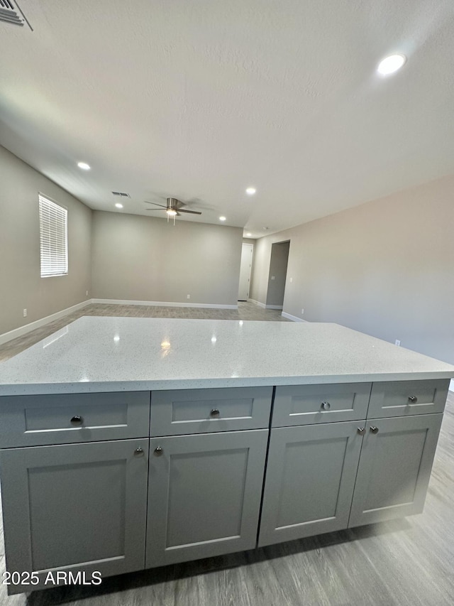 kitchen featuring visible vents, open floor plan, ceiling fan, light wood-type flooring, and gray cabinetry