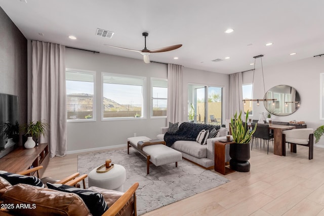 living room with ceiling fan and light hardwood / wood-style floors