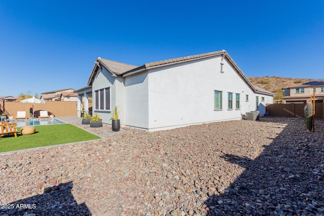 rear view of house featuring central AC unit and a patio area