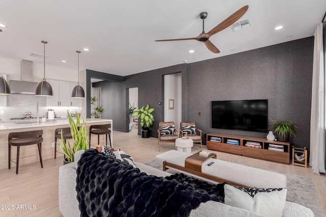 living room featuring ceiling fan and light wood-type flooring