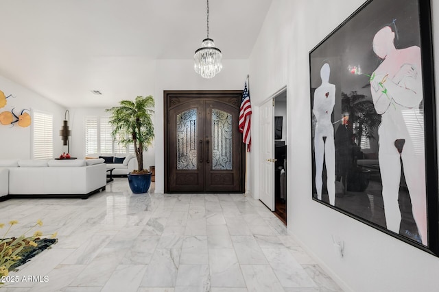 entrance foyer featuring french doors and a chandelier