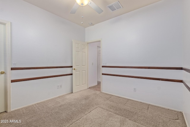 empty room with ceiling fan, carpet floors, and visible vents