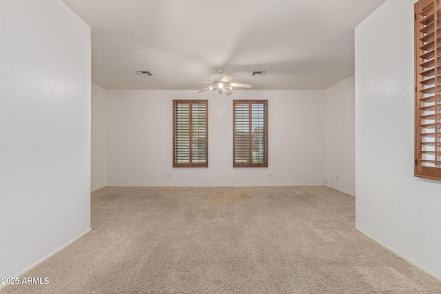 empty room with ceiling fan, carpet flooring, and visible vents