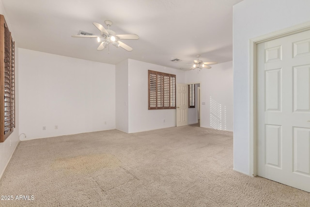 carpeted empty room featuring ceiling fan and visible vents