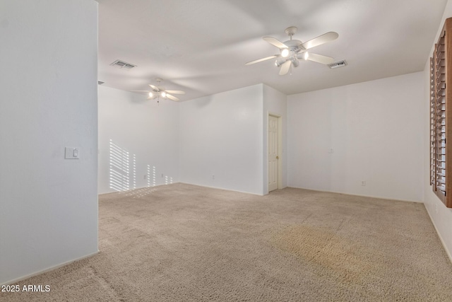 carpeted spare room with ceiling fan and visible vents