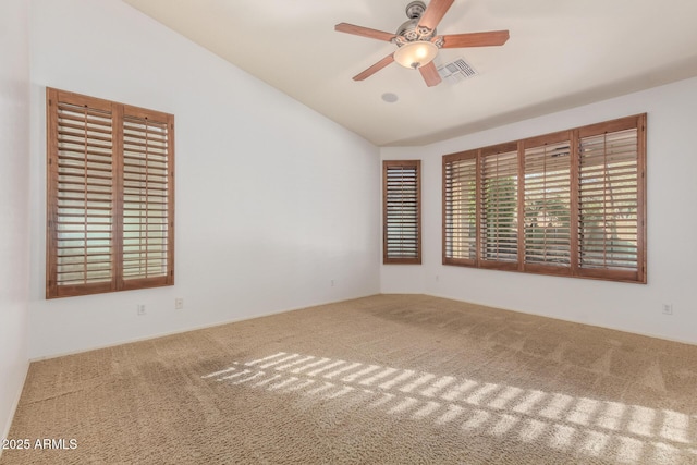 carpeted empty room with a ceiling fan, lofted ceiling, and visible vents