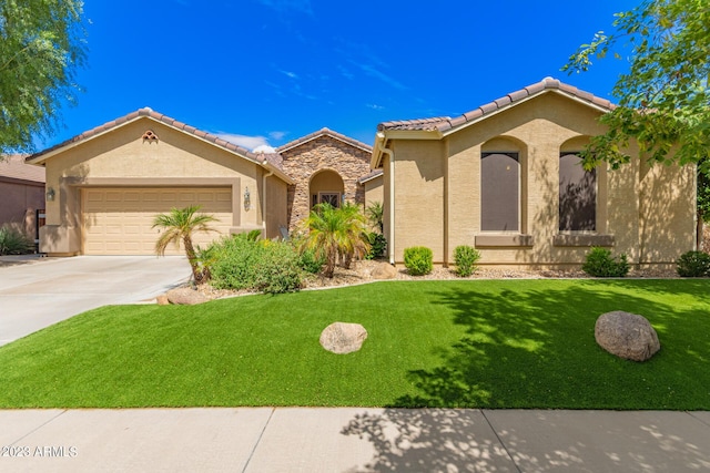 mediterranean / spanish-style home featuring an attached garage, concrete driveway, stone siding, stucco siding, and a front lawn