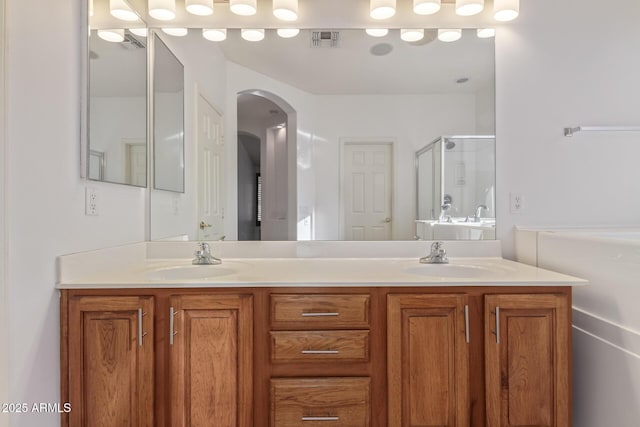 full bathroom featuring a stall shower, visible vents, a sink, and double vanity