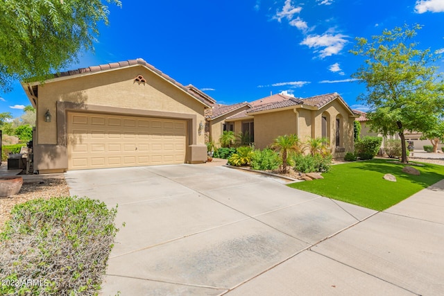 mediterranean / spanish-style home with an attached garage, a tile roof, concrete driveway, and stucco siding