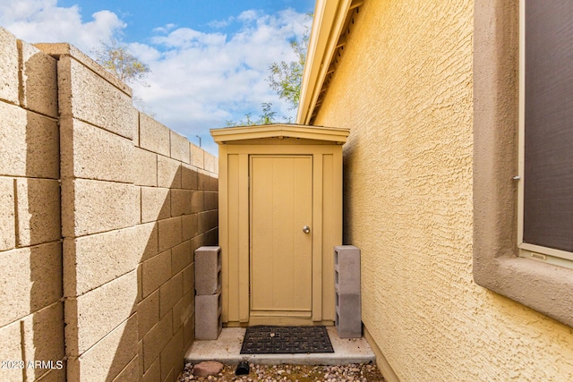 property entrance with fence and stucco siding