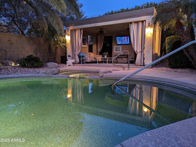 view of swimming pool with a patio, a pool with connected hot tub, fence, and a ceiling fan