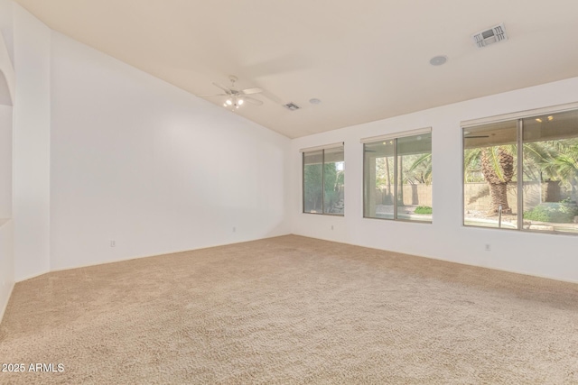 unfurnished room featuring carpet floors, lofted ceiling, visible vents, and a ceiling fan