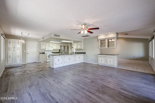 kitchen featuring kitchen peninsula, light wood-type flooring, white appliances, ceiling fan with notable chandelier, and white cabinets